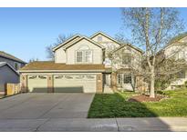 Charming two-story home with a three car garage and manicured front lawn at 10984 Alcott Dr, Denver, CO 80234