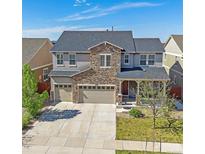 Beautiful two-story home featuring a stone facade, three-car garage, and manicured front lawn at 14997 Elsinore Ave, Parker, CO 80134