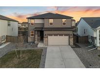 Beautiful two-story home with a two car garage, stone accents, and a well-manicured lawn at 18014 Tree Sparrow Ave, Parker, CO 80134