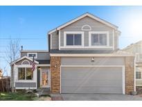 Charming two-story home featuring gray siding, brick accents, and a two-car garage at 180 S Carlton St, Castle Rock, CO 80104