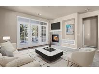 Bright living room features a fireplace, balcony access and modern neutral finishes at 2210 S Vaughn Way # 103, Aurora, CO 80014