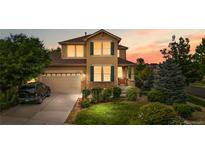Inviting two-story home with a well-manicured lawn, beautiful landscaping, and a two-car garage at dusk at 20964 E Greenwood Pl, Aurora, CO 80013