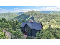 Stunning multi-story home nestled amongst the trees with mountain views at 14980 Elk Mountain Trl, Littleton, CO 80127