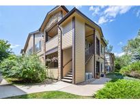 Tan three-story building with stairs and landscaping at 4875 S Balsam Way # 12-203, Littleton, CO 80123