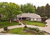 Landscaped front yard with circular driveway and mature trees framing the beautiful exterior of the home at 5340 S Logan Dr, Greenwood Village, CO 80121