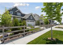 Charming two-story home featuring gray siding, a well-manicured lawn, and a quaint wooden fence at 13334 Blue Amber Ct, Parker, CO 80134