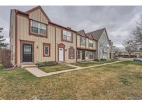 Street view of colorful townhomes featuring neat lawns, walkways, and varied architectural details at 14486 E Hawaii Cir # D, Aurora, CO 80012