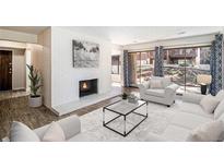 Bright living room featuring a white-painted fireplace, stylish furniture, and large windows at 500 Manhattan Dr # B1, Boulder, CO 80303