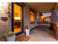 Charming front porch with swing, brick accents, and a view into the dining room through the front door at 3044 W 37Th Ave, Denver, CO 80211