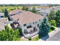View of the back of the home with white fence and patio with grill and grassy area at 232 Whitehaven Cir, Highlands Ranch, CO 80129