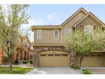 Charming two-story home featuring a stone accent, attached garage, and well-maintained landscaping at 10067 Bluffmont Ct, Lone Tree, CO 80124