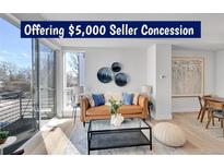 Bright living room with hardwood floors, modern furniture, and a large window at 1007 Chase St, Lakewood, CO 80214