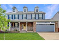 Charming two-story home with a well-manicured lawn and attached two-car garage at 9954 Heywood St, Highlands Ranch, CO 80130