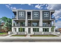 Modern three-story condo building featuring a sleek gray facade, large windows, and multiple private balconies at 7881 W 51St Ave # B, Arvada, CO 80002