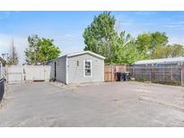 Charming gray home with white trim, fenced yard, and concrete driveway in a well-maintained community at 8430 Madison Way, Denver, CO 80229