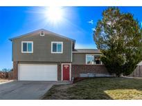 Charming two-story home with a well-maintained lawn, a two-car garage, and a red front door at 7862 S Independence Way, Littleton, CO 80128