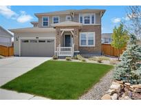 Beautiful two-story home featuring a well-maintained lawn and a charming stone-accented entryway at 87 Green Fee Cir, Castle Pines, CO 80108