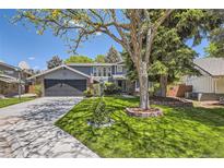 Charming two-story home with a well-manicured lawn, mature trees, and a two-car garage at 6338 S Oneida Ct, Centennial, CO 80111