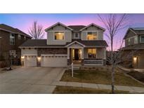 Charming two-story home featuring a three-car garage and a beautiful stone accent on the facade at 13561 W 87Th Dr, Arvada, CO 80005