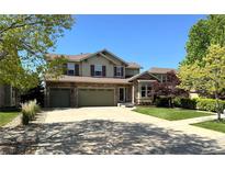 Charming two-story home with a three car garage, stone accents, mature trees, and manicured lawn at 24714 E Quarto Pl, Aurora, CO 80016