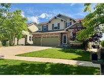 Inviting two-story home featuring a well-manicured lawn and a convenient two-car garage at 24714 E Quarto Pl, Aurora, CO 80016