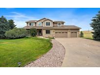 Inviting two-story home with a three-car garage, stone accents, and a well-manicured lawn at 5861 E Valley Hi Dr, Parker, CO 80138