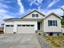 Charming home featuring a three-car garage, modern siding, and a well-maintained yard at 229 Wooten Ave, Brighton, CO 80601