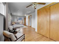 Bright bedroom featuring wood floors, a ceiling fan, a large closet, and comfortable seating at 375 Kohl St, Broomfield, CO 80020