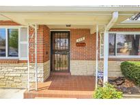 Inviting brick porch with stone accents and ornamental metal supports offers classic charm at 375 Kohl St, Broomfield, CO 80020