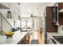 Modern kitchen with stainless steel appliances, hardwood floors, and a large center island at 1581 Wolff St, Denver, CO 80204