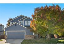 Charming blue two-story home with stone accents, mature landscaping, and an attached two-car garage at 1540 Meachum Way, Erie, CO 80516