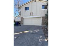 Exterior shot of a two-car garage with concrete driveway and partial brick facade at 6610 W 74Th Ave, Arvada, CO 80003