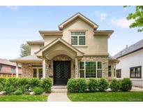 Charming two-story home featuring a stone-accented facade, manicured lawn, and inviting entryway at 1214 S Fillmore St, Denver, CO 80210