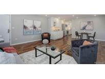 Inviting living room featuring hardwood floors, modern furnishings, and an open floor plan with eat-in kitchen at 909 N Logan St # 1B, Denver, CO 80203