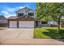 Charming two-story home featuring a stone accent wall, attached garage, and a well-manicured front yard at 1325 Kingsfield St, Castle Rock, CO 80104