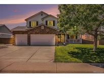 Charming two-story home featuring a stone-accented facade, a well-manicured lawn, and a spacious three-car garage at 1325 Kingsfield St, Castle Rock, CO 80104