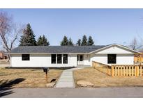 Charming single-story home with a modern white exterior, black trim, and a well-manicured front yard at 11825 W 25Th Ave, Lakewood, CO 80215