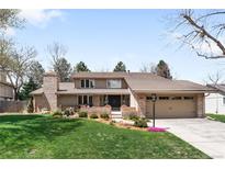 Charming two-story home featuring a lush lawn, brick accents, and an attached two-car garage at 4833 E Links Cir, Centennial, CO 80122