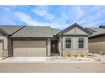 Charming home featuring stone accents, a well-kept lawn, and an attached two-car garage at 11791 Barrentine Loop, Parker, CO 80138