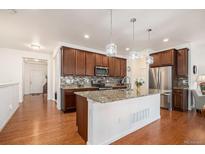 Modern kitchen with stainless steel appliances, granite countertops, and a large island at 11791 Barrentine Loop, Parker, CO 80138