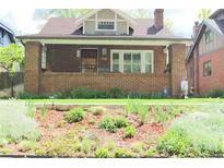 Charming brick home with a cozy front porch and well-manicured garden at 832 S Gilpin St, Denver, CO 80209