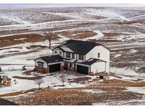 Two-story house with three-car garage, viewed from above in snowy landscape at 3654 Paintbrush Ln, Parker, CO 80138