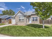 Charming brick home featuring a well-manicured lawn, attached garage, and inviting front entrance at 4912 Altura St, Denver, CO 80239
