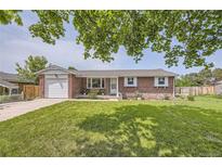 Charming brick ranch-style home featuring a well-manicured lawn and inviting front porch at 10633 E 6Th Pl, Aurora, CO 80010