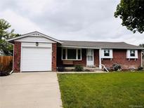 Charming brick home featuring a well-maintained lawn, attached garage and lovely curb appeal at 10633 E 6Th Pl, Aurora, CO 80010