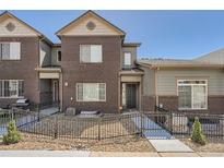 Charming townhome showcasing a well-maintained brick facade, stylish gray accents, and neat landscaping at 6634 S Patsburg St, Aurora, CO 80016