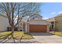 Charming two-story home with a well-maintained lawn, mature tree, and a two-car garage at 11570 Depew Ct, Westminster, CO 80020
