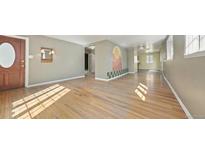 Sun-drenched living room with hardwood floors and unique wall decor offers a cozy and inviting space at 2572 S Vine St, Denver, CO 80210