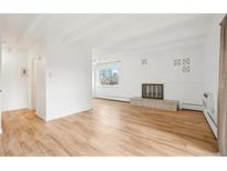 Bright living room features hardwood floors, a decorative fireplace, and large windows with city views at 250 N Pearl St # 310, Denver, CO 80203