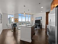 Modern kitchen with stainless steel appliances, island with seating, and expansive city views at 891 14Th St # 3411, Denver, CO 80202